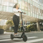 Persona circulando en patinete eléctrico por una calle urbana