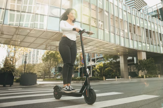 Persona circulando en patinete eléctrico por una calle urbana