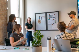 Equipo de trabajo revisando documentación y producto digital en una sala de reuniones