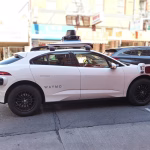 Vehículo autónomo Waymo circulando por una calle urbana, asociado a robotaxis y regulación municipal.