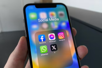 Persona usando un teléfono móvil con aplicaciones sociales en pantalla.
