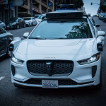 Coche autónomo Waymo circulando por una calle urbana