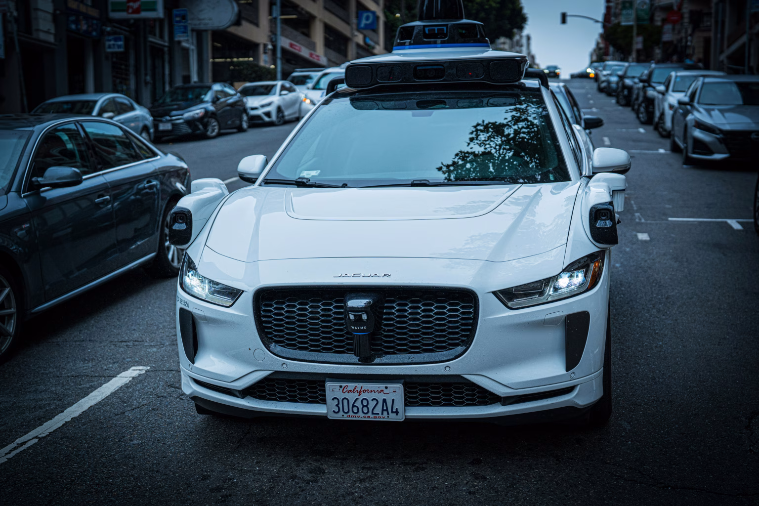 Coche autónomo Waymo circulando por una calle urbana