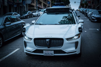 Coche autónomo Waymo circulando por una calle urbana