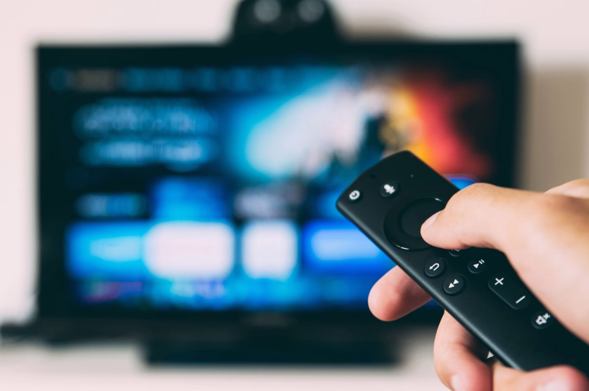 Mando a distancia frente a una pantalla de televisión, relacionado con plataformas de streaming