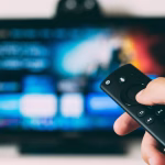 Mando a distancia frente a una pantalla de televisión, relacionado con plataformas de streaming