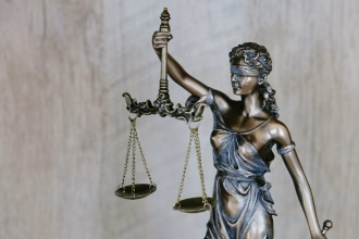 Mesa de trabajo legal con documentos y ordenador portátil para gestión jurídica digital.
