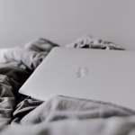 Portátil en una cama, imagen relacionada con herramientas de diseño y productividad digital