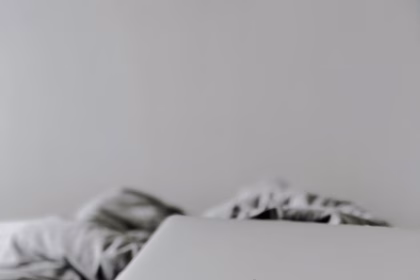 Portátil en una cama, imagen relacionada con herramientas de diseño y productividad digital