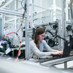 Operario revisando datos de producción en una fábrica digitalizada.