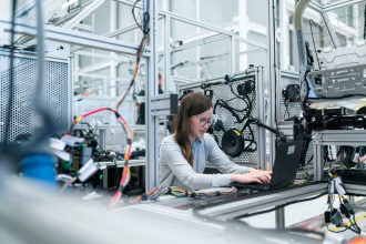 Operario revisando datos de producción en una fábrica digitalizada.