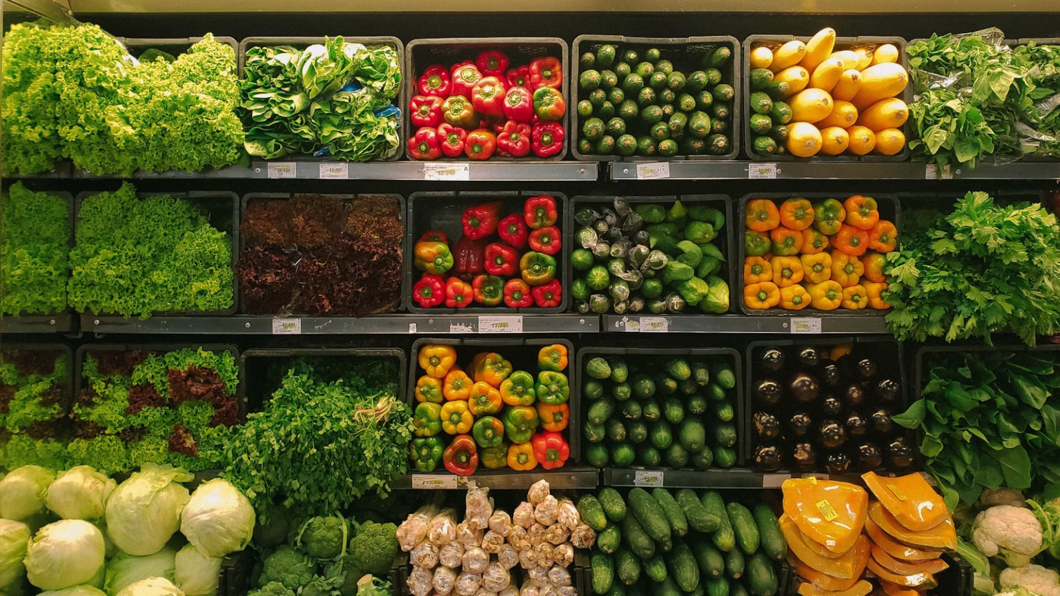 Cajas de frutas y verduras frescas en un mercado, imagen relacionada con conservación alimentaria