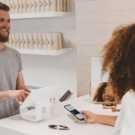 Persona pagando con tarjeta en un terminal, imagen asociada a comercio agente y pagos digitales.