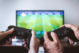 Persona usando un mando frente a una pantalla, imagen asociada a videojuegos y entretenimiento digital.
