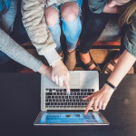 Persona creando contenido con un teléfono y un ordenador portátil, imagen asociada a marketing de influencers.