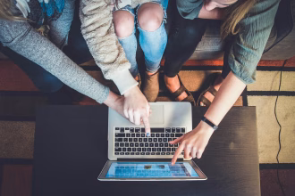 Persona creando contenido con un teléfono y un ordenador portátil, imagen asociada a marketing de influencers.