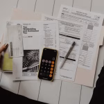 Documentos financieros y calculadora sobre una mesa para ilustrar una posible operación fintech
