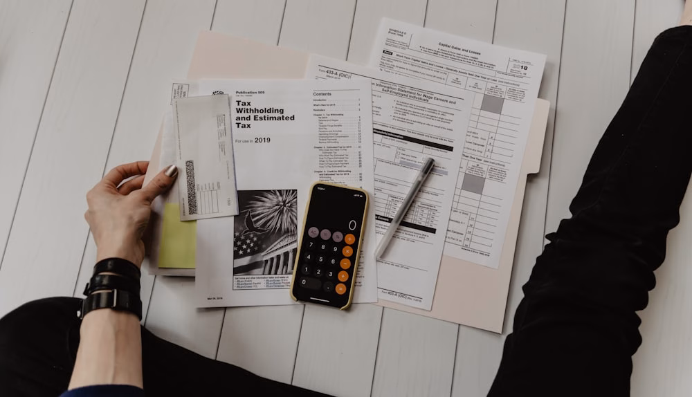 Documentos financieros y calculadora sobre una mesa para ilustrar una posible operación fintech