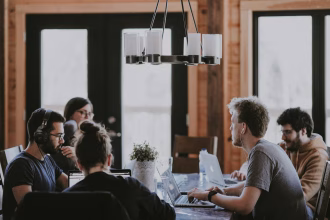 Equipo de una startup trabajando alrededor de un ordenador portátil en una oficina