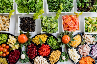 Mesa de trabajo con alimentos saludables y documentos empresariales, imagen asociada a inversión en alimentación ecológica.