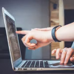 Programador trabajando con código en varios monitores